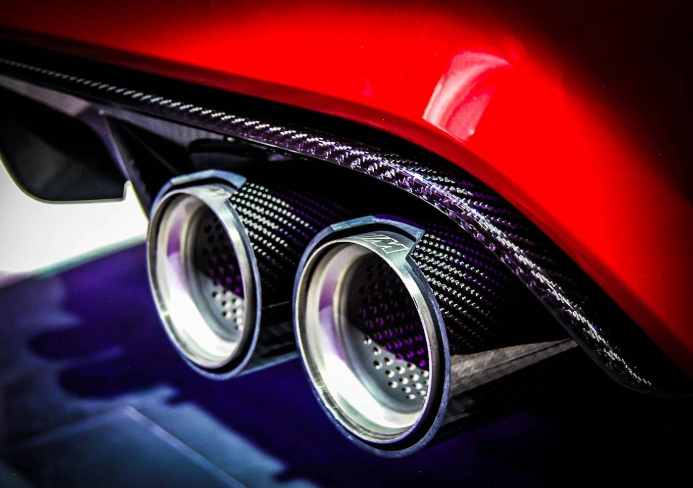 Carbon fibre quad exhaust tips on a red performance car